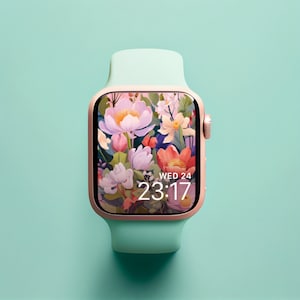 May include: A rose gold smartwatch with a mint green band. The watch face displays a floral pattern with a digital clock that reads "WED 24 23:17".