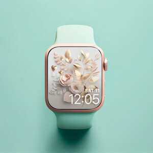 May include: A rose gold smartwatch with a mint green band. The watch face features a floral design with gold accents and a digital clock displaying "SAT 11 12:05".