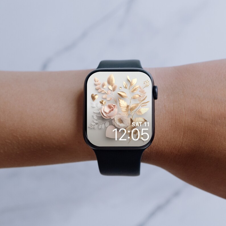 May include: A black smartwatch with a white watch face displaying a floral design with gold accents and the time "SAT 11 12:05".