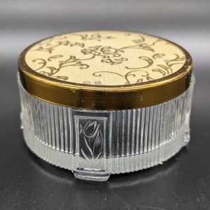 May include: A vintage glass and gold trinket box with a floral design on the lid. The box has a ribbed design and a decorative tulip on the side.