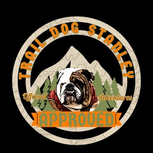 Könnte beinhalten: Ein beiger Kreis mit dem Text "Trail Dog Stanley" in orangefarbener Schrift. Im Inneren des Kreises befindet sich ein Cartoon-Bild eines Bulldoggen, der eine rote Jacke trägt, mit dem Text "Offroad Adventures" und "APPROVED" in orangefarbener Schrift.