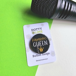 May include: Black button badge with white text that reads "Karaoke Queen" and a gold crown. The badge is on a white card with the text "Dotty Lime Button Badge @dottylimedesigns".