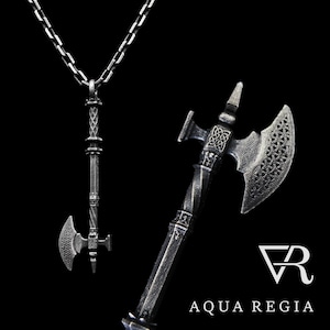 May include: A silver axe pendant necklace with intricate details. The axe head is detailed with a Celtic knot design. The pendant is attached to a silver chain.