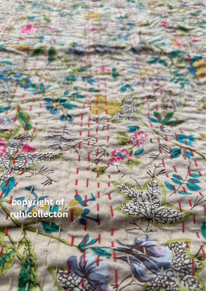 May include: A close-up of a beige fabric with a floral pattern. The fabric is quilted with red and white stitching. The text "copyright of ruhicollection" is visible in the bottom left corner.