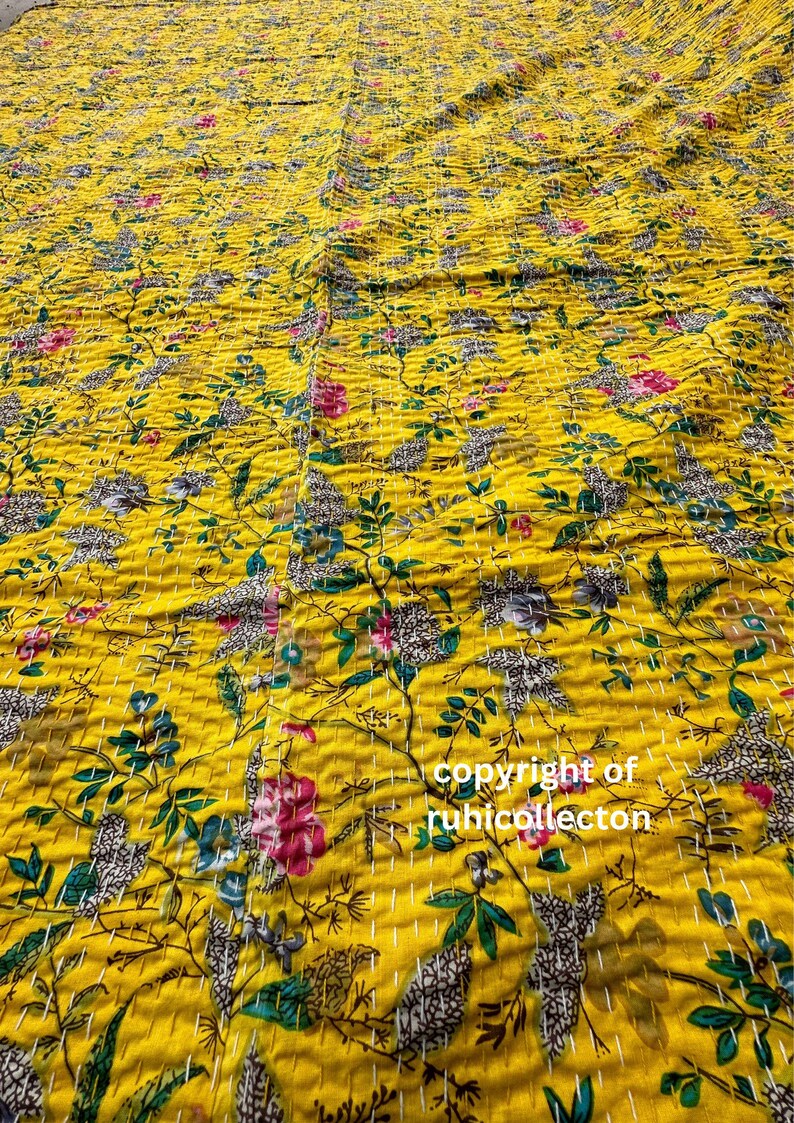 K&ouml;nnte beinhalten: Eine gelbe Kantha-Steppdecke mit einem Blumenmuster. Die Steppdecke ist aus Baumwolle und hat ein handgesticktes Design. Die Steppdecke ist perfekt, um jedem Raum einen Hauch von Farbe und W&auml;rme zu verleihen.