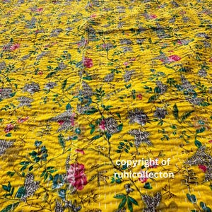 May include: A yellow kantha quilt with a floral pattern. The quilt is made of cotton and has a hand-stitched design. The quilt is perfect for adding a touch of color and warmth to any room.