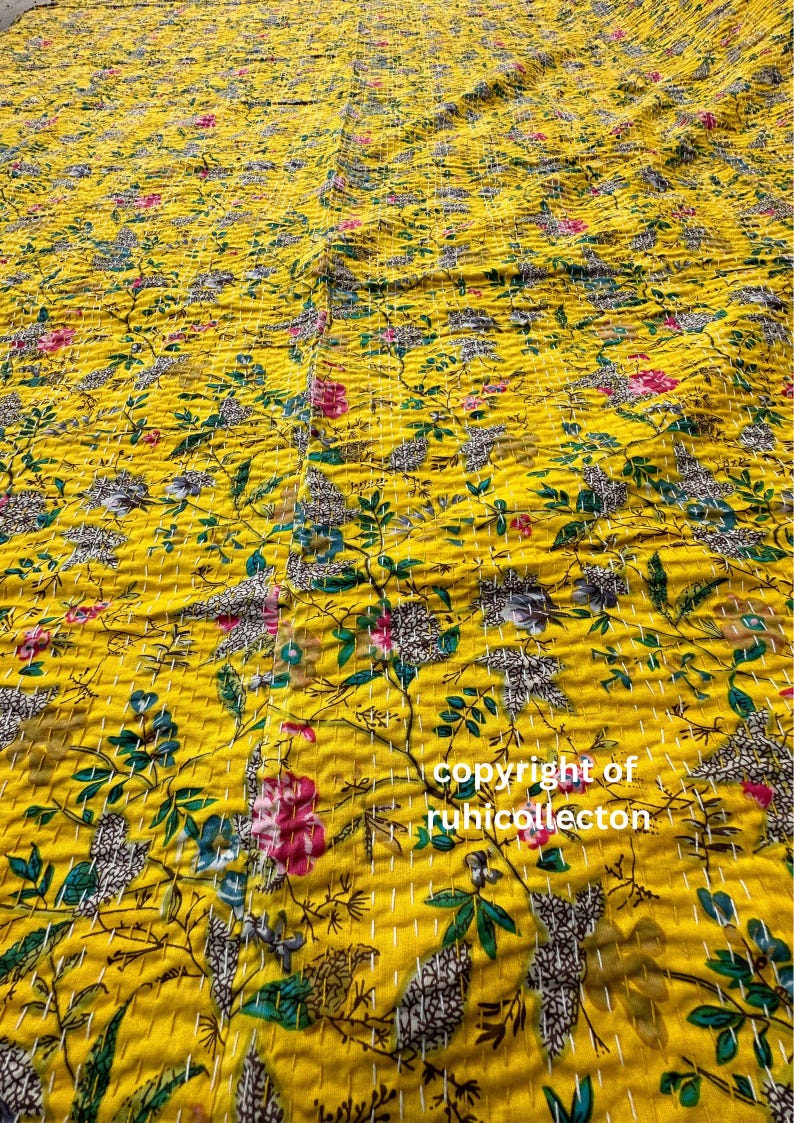 May include: A yellow kantha quilt with a floral pattern. The quilt is made of cotton and has a hand-stitched design. The quilt is perfect for adding a touch of color and warmth to any room.
