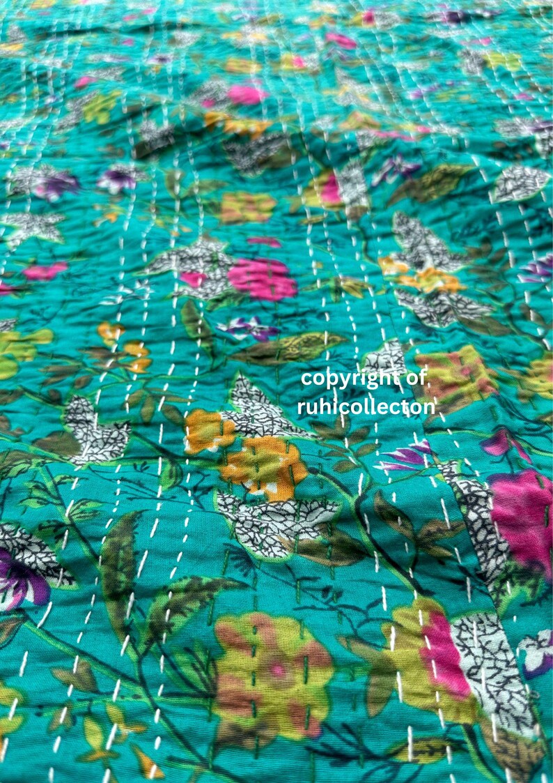 May include: A teal blue kantha quilt with a floral pattern in shades of pink, yellow, and white. The quilt is hand-stitched with white thread and has a textured surface. The text "copyright of, ruhilcollector" is visible in the lower right corner of the image.