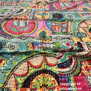 Könnte beinhalten: Eine lebendige Patchwork-Steppdecke mit einem Kaleidoskop aus Farben und Mustern. Das Design zeigt große, stilisierte Blumen- und geometrische Motive in Rosa, Blau, Gelb und Orange. Die Steppdecke ist mit weißem Faden handgenäht.