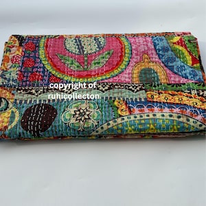 Pu&ograve; includere: Tessuto piegato e colorato con un design patchwork. Il tessuto presenta una variet&agrave; di motivi, tra cui forme floreali e geometriche, nelle tonalit&agrave; del rosa, blu, verde e giallo. Il testo "copyright of ruhicollecton" &egrave; visibile.