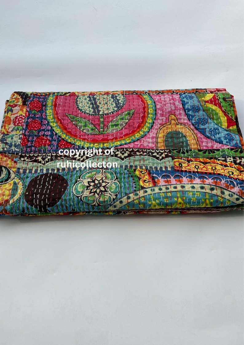 Pu&ograve; includere: Tessuto piegato e colorato con un design patchwork. Il tessuto presenta una variet&agrave; di motivi, tra cui forme floreali e geometriche, nelle tonalit&agrave; del rosa, blu, verde e giallo. Il testo "copyright of ruhicollecton" &egrave; visibile.