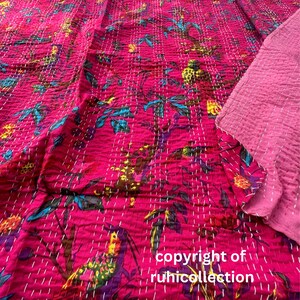May include: A vibrant pink textile with a floral pattern in teal, yellow, and purple, hand-stitched with white thread. The text "copyright of ruhicollection" is visible. The fabric is likely a quilt or blanket.