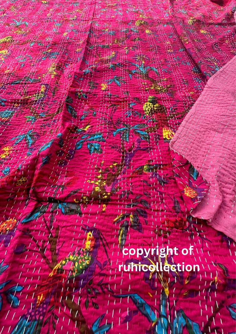 May include: A vibrant pink textile with a floral pattern in teal, yellow, and purple, hand-stitched with white thread. The text "copyright of ruhicollection" is visible. The fabric is likely a quilt or blanket.