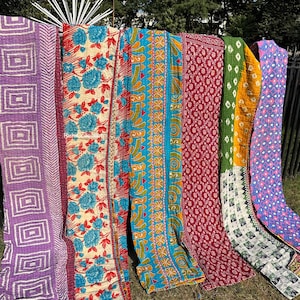 May include: Six colorful kantha quilts with various patterns, including floral, geometric, and paisley designs. The quilts are made of recycled saris and are perfect for adding a touch of bohemian style to any room.