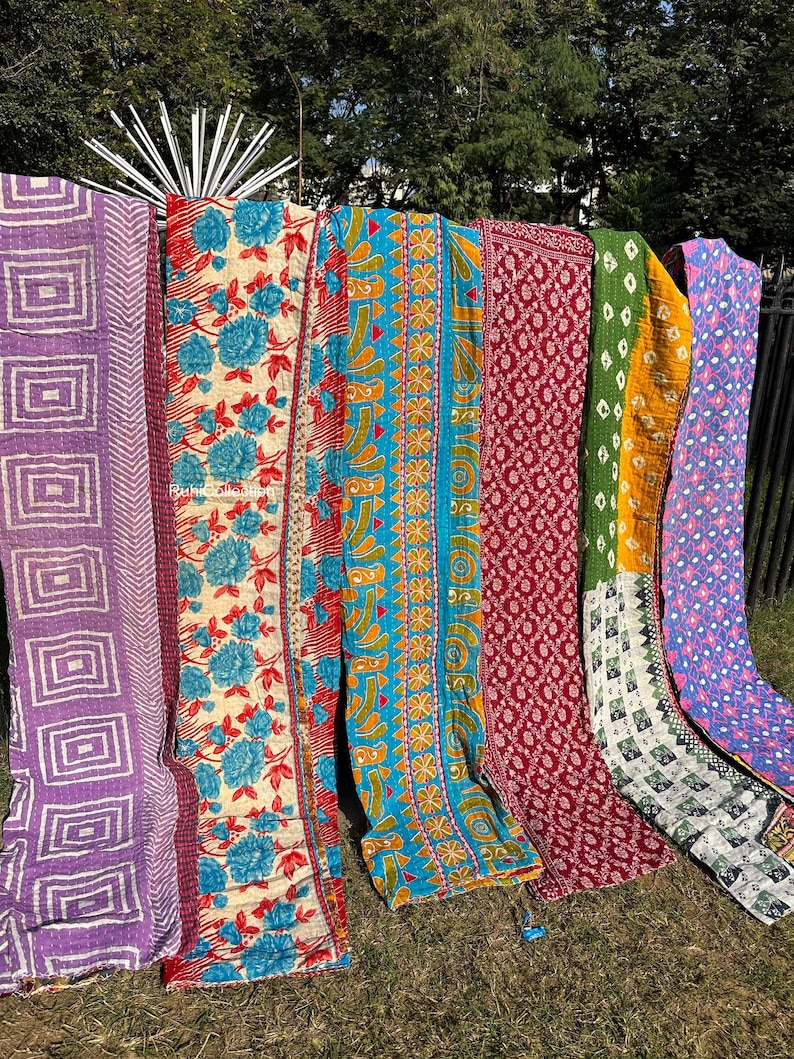 May include: Six colorful kantha quilts with various patterns, including floral, geometric, and paisley designs. The quilts are made of recycled saris and are perfect for adding a touch of bohemian style to any room.