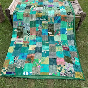 May include: A patchwork quilt with a vibrant mix of green hues, arranged in a grid pattern. The quilt features various fabric textures and patterns, with a green border. The text "RuniCollection" is visible on the quilt.