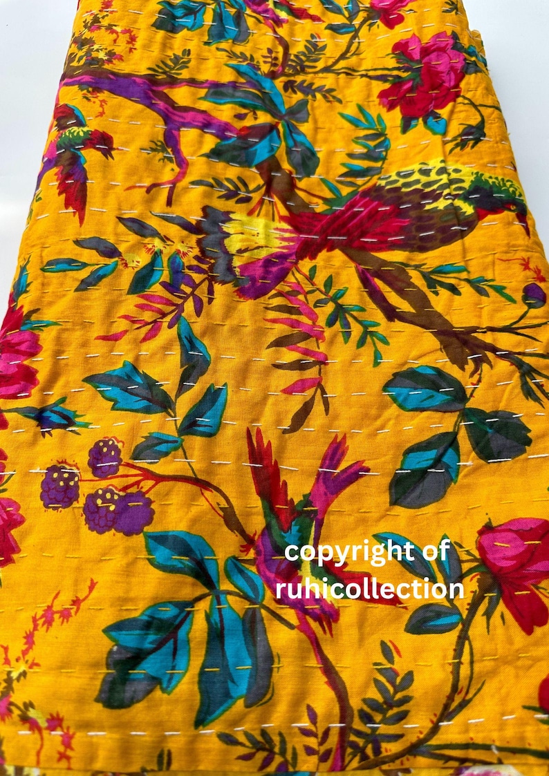 May include: Yellow fabric with a vibrant floral and bird pattern. The design features colorful birds, flowers, and leaves in shades of red, purple, blue, and green. White stitching accents the design. The text "copyright of ruhicollection" is visible.