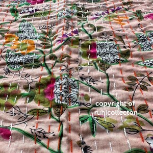 May include: A close-up of a pink fabric with a floral pattern. The fabric is quilted with white and orange thread. The text "copyright of ruhicollecton" is visible in the bottom right corner.