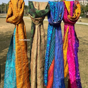 Op de afbeelding: Vier kleurrijke zijden sjaals met verschillende patronen en kleuren, waaronder oranje, blauw, groen en roze. De sjaals hangen aan een lijn en zijn gemaakt van een zachte, luxe stof.  #RuniCollection