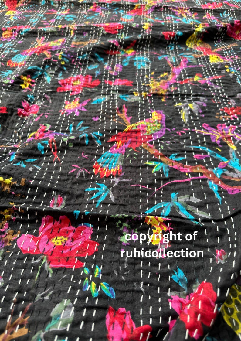 May include: Black fabric with a colorful floral and bird pattern. The design features red, pink, blue, and yellow flowers and birds on branches. The fabric is stitched with white thread. The text "copyright of ruhicollection" is visible.