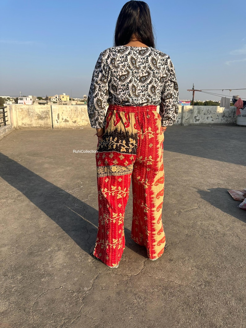 May include: A pair of red and cream patchwork pants with a paisley print. The pants have a wide leg and are made from a soft, comfortable fabric.