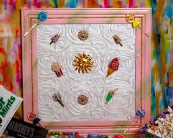 Könnte beinhalten: Ein rosa gerahmtes Bild mit weißem Hintergrund, das verschiedene bunte, juwelenbesetzte und glitzernde Eiswaffel- und Eis am Stiel-Designs zeigt. Der Rahmen ist mit einem glitzernden rosa und weißen Finish verziert.