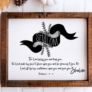 May include: A black and white print with the word "Shalom" in a banner with floral accents. The print includes a Bible verse from Numbers 6:24-21, "The Lord bless you and keep you. The Lord make his face to shine upon you and be gracious to you. The Lord lift up his countenance upon you and give you Shalom."