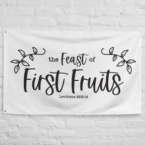 May include: White banner with black text and illustrations. The text reads "the Feast of First Fruits" with the scripture reference "Leviticus 23:9-14" below. The banner features two stylized leafy branches.