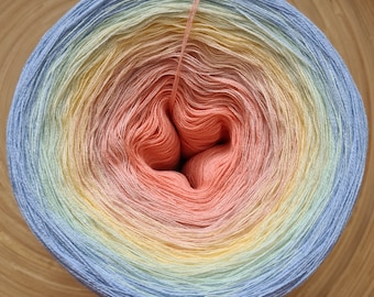 May include: A ball of yarn with a gradient of colors, including light blue, yellow, peach, and pink. The yarn is tightly wound, with a strand extending from the center. The yarn is likely used for knitting or crocheting projects.
