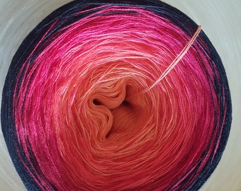 May include: A vibrant ball of yarn with a gradient of colors, transitioning from black to pink, red, and orange. A single strand of yarn extends from the center. The yarn is likely used for knitting or crocheting projects.
