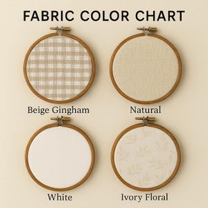 May include: Fabric color chart featuring four embroidery hoops. The hoops have wooden frames and hold different fabric samples: beige gingham, natural, white, and ivory floral. The text "FABRIC COLOR CHART" is at the top.