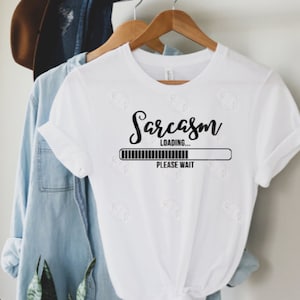 May include: White t-shirt with black text that reads "Sarcasm Loading... Please Wait" with a progress bar underneath.