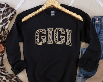 May include: Black sweatshirt with the word "GIGI" in large, gold leopard print letters.