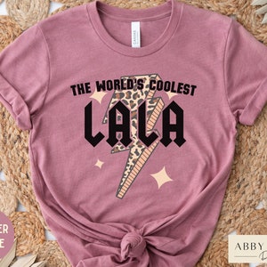 May include: A heather mauve t-shirt with a graphic of a lightning bolt with a leopard print design. The text "The World's Coolest Lala" is printed on the shirt.