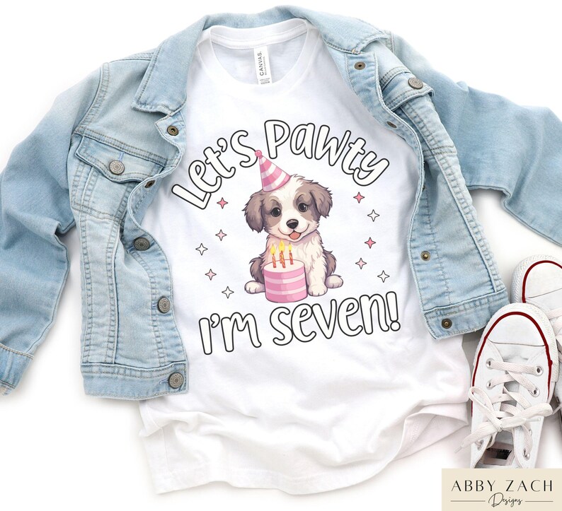 May include: White t-shirt with a cute cartoon dog wearing a party hat and holding a pink cake. The text "Let's Pawty I'm Seven!" is printed on the shirt.