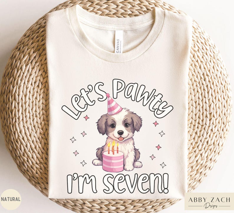 May include: A white t-shirt with the text "Let's Pawty I'm Seven!" in black. A cartoon dog wearing a pink party hat sits next to a pink cake with candles.