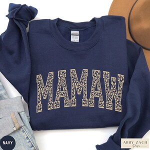 May include: Navy blue sweatshirt with a leopard print "Mamaw" design.