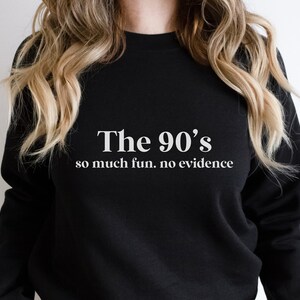 May include: Black sweatshirt with white text that reads "The 90's so much fun. no evidence"