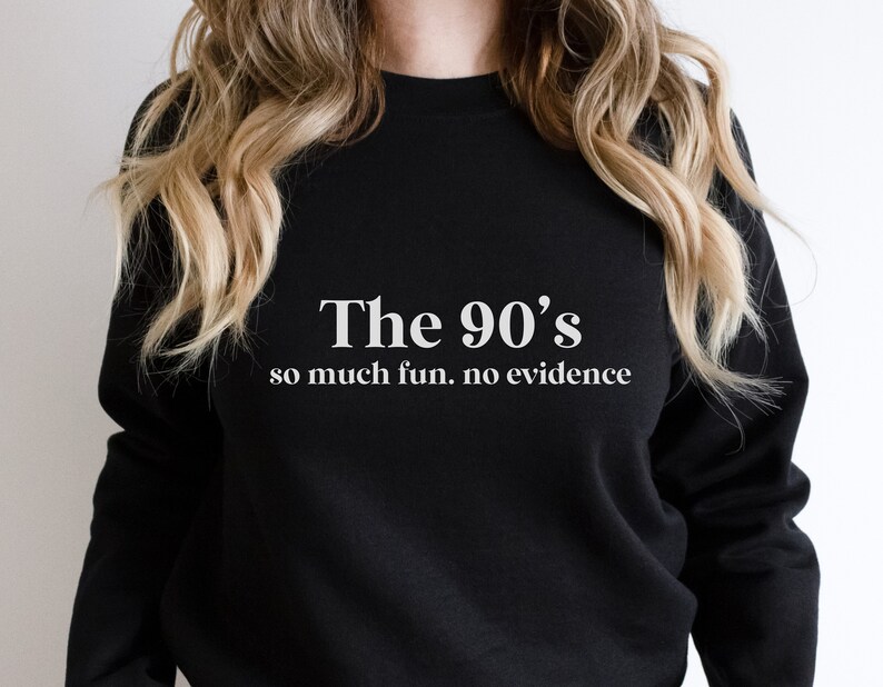 May include: Black sweatshirt with white text that reads "The 90's so much fun. no evidence"