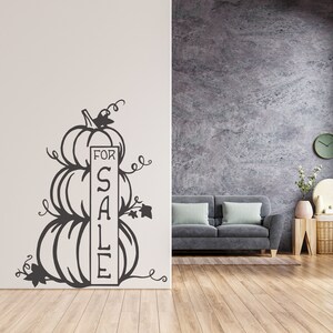 Puede incluir: Silueta en blanco y negro de tres calabazas apiladas una encima de la otra con un cartel que dice "FOR SALE" en una pared blanca.