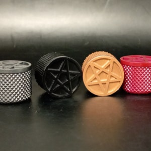 以下が含まれることがあります： 上部に5つのポイントの星形のデザインが施された、小さな円筒形の容器が4つあります。容器は黒、茶色、赤、銀色です。