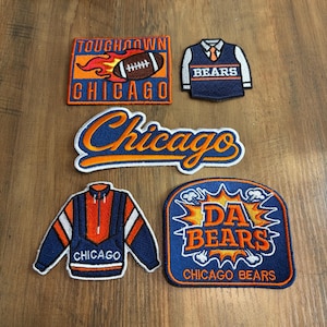 May include: Five embroidered patches featuring Chicago Bears themes. One rectangular patch shows a football with flames and the text TOUGHNOWN CHICAGO. Another is a vest shape with BEARS text. A script patch reads Chicago. A jacket patch and a DA BEARS patch.
