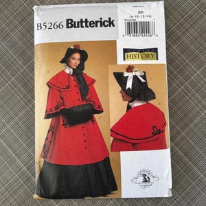 May include: A Butterick sewing pattern for a historical costume. The pattern features a red coat and skirt with black accents, a black hat, and a black muff. The pattern includes the text "B5266 Butterick" and "HISTORY".