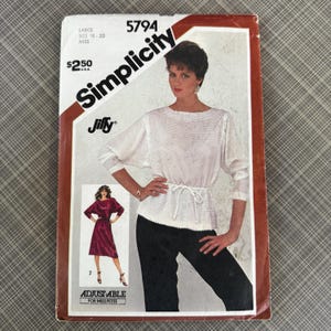 May include: A vintage Simplicity sewing pattern, size 18-20, featuring a woman in a white top and black pants. The pattern includes a smaller image of a burgundy dress. The text on the pattern reads "Jiffy" and "Adjustable for Miss Petite."