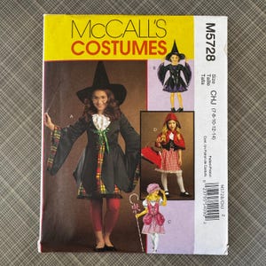 May include: A McCall's Costumes pattern envelope featuring illustrations of children's Halloween costumes. The main image shows a witch costume with a black dress, hat, and red leggings. Other costumes include a fairy and Little Red Riding Hood.