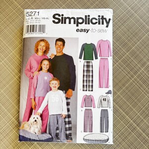 May include: Simplicity easy-to-sew pattern for pajamas. The pattern includes illustrations of pajama sets in various colors and styles, including plaid pants and raglan sleeve tops. The pattern number is 5271, and the size range is XS-XL.