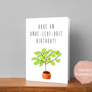 Könnte beinhalten: Eine weiße Karte mit dem Text "Have an Un-Leaf-Able Birthday!" und einer grünen Pflanze in einem braunen Topf.