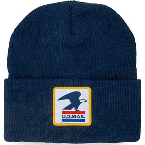 May include: A navy blue knit beanie with a cuffed brim. Centered on the cuff is a square patch featuring a white background with a yellow border. The patch displays a dark blue eagle silhouette above a red and blue stripe with the text U.S.MAIL.