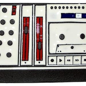 May include: A white enamel pin shaped like a portable cassette recorder with black outlines. The design features a central cassette tape compartment, two vertical red sliders, a series of black circular buttons, and a row of playback control icons.