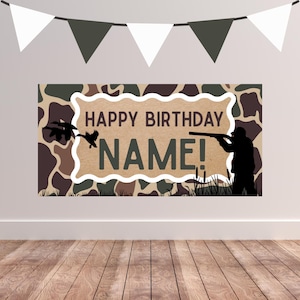 May include: A birthday banner with a camouflage pattern background. The banner features the text "HAPPY BIRTHDAY NAME!" with a silhouette of a person hunting and ducks flying. White and dark green triangle flags are strung above the banner.